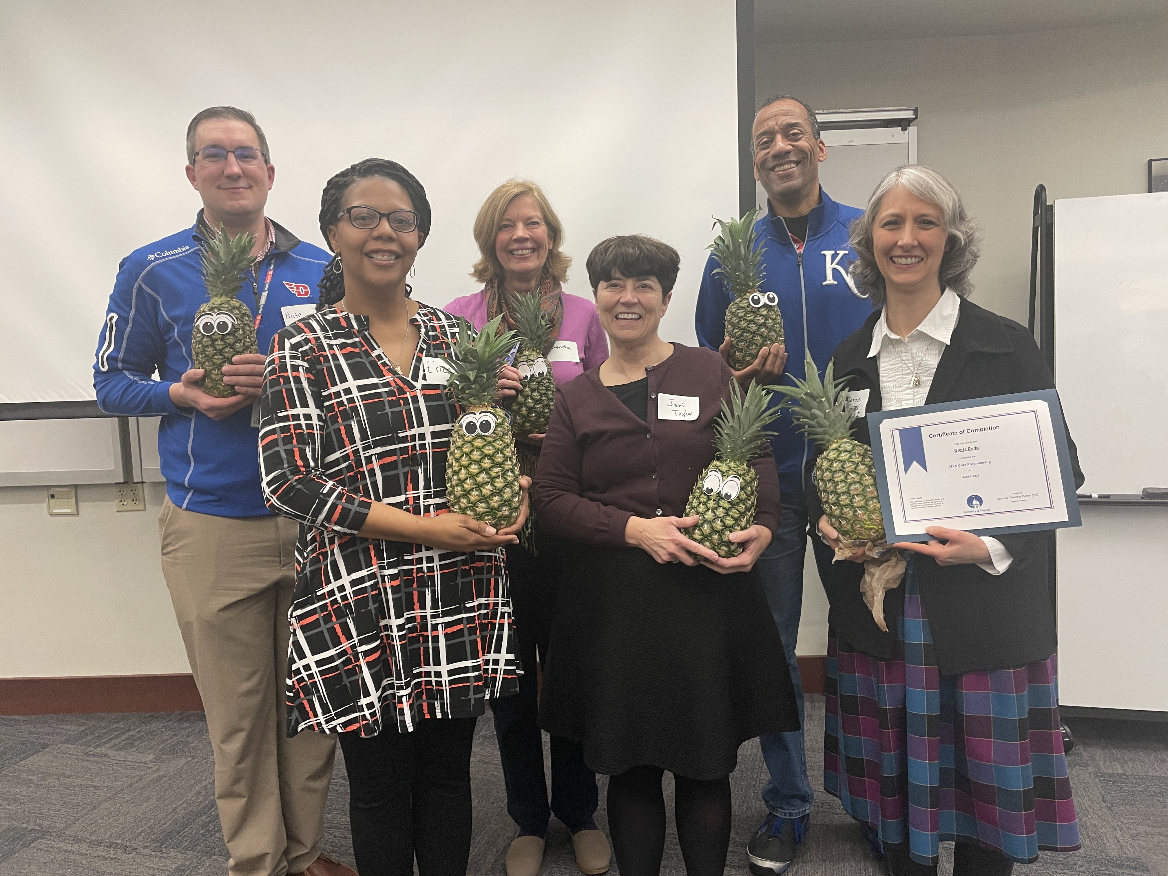 Faculty members Nathan Henderson, Erica Hunter, Brenda Lecklider, Jeri Taylor, Verb Washington, and Gloria Dodd pose with pineapples to signify their graduation from ATLS.