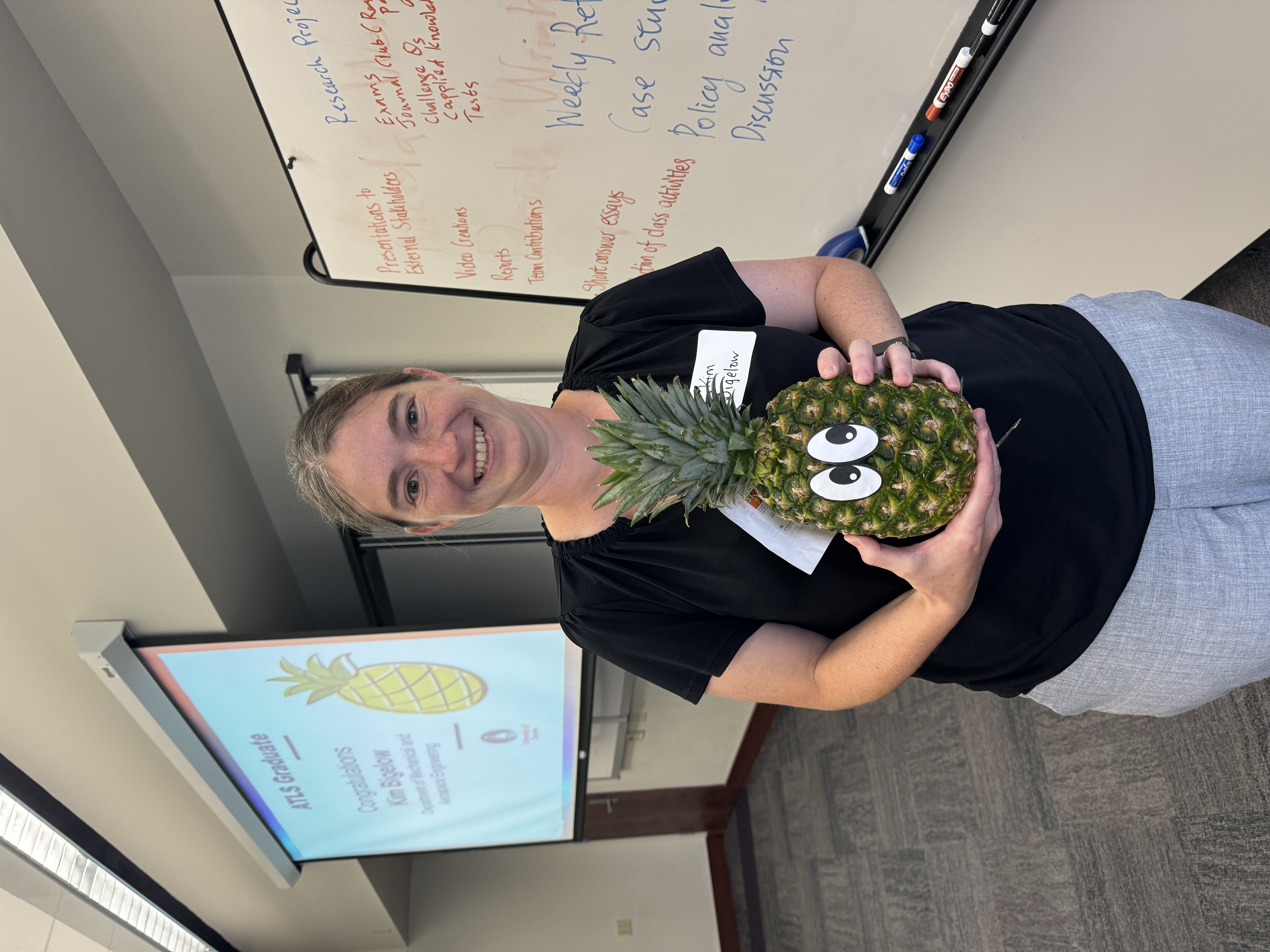 Faculty member Kim Bigelow poses with a pineapple to signify her graduation from ATLS.