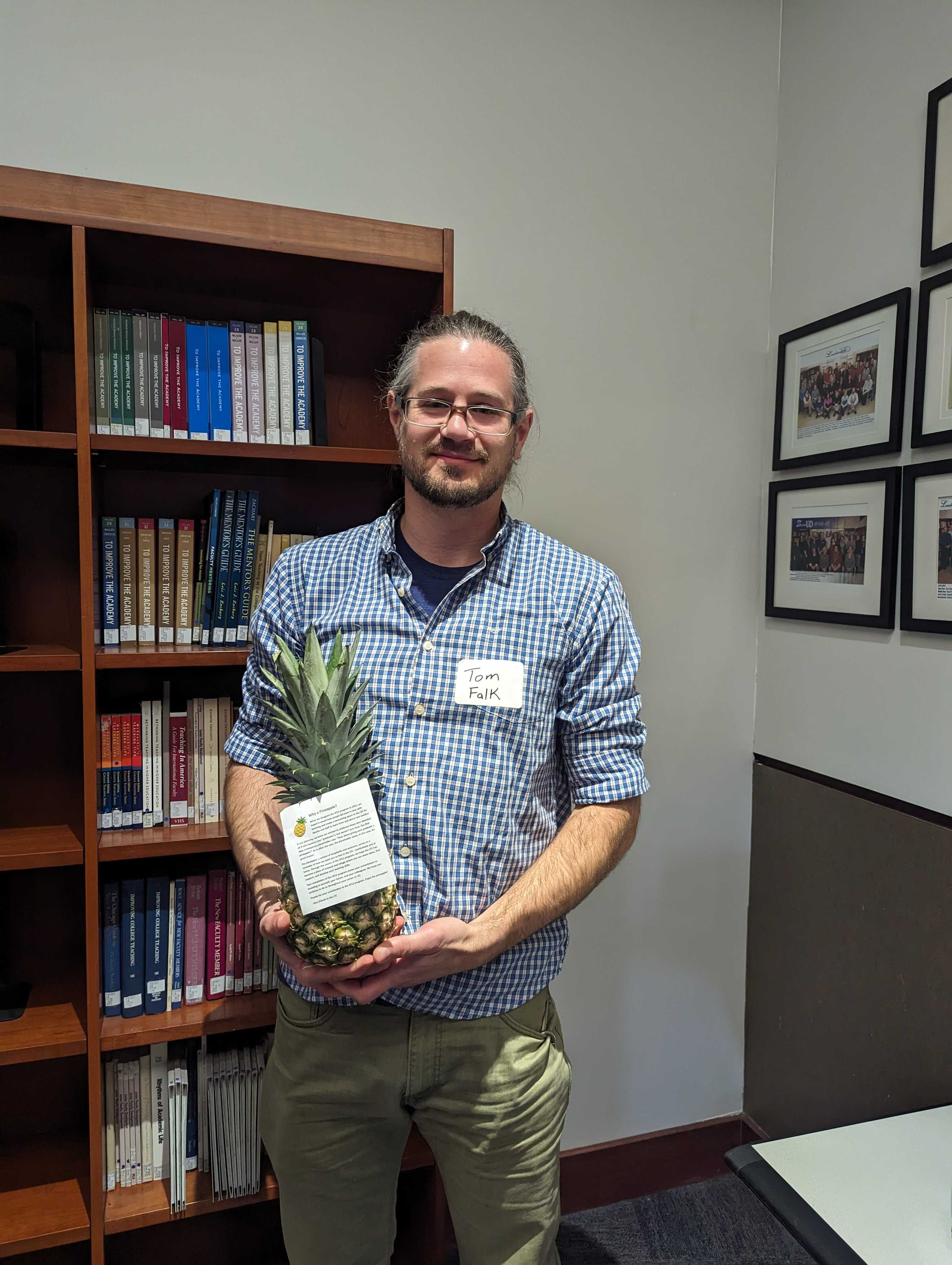 Faculty member Thomas Falk poses with a pineapple to signify graduation from ATLS.
