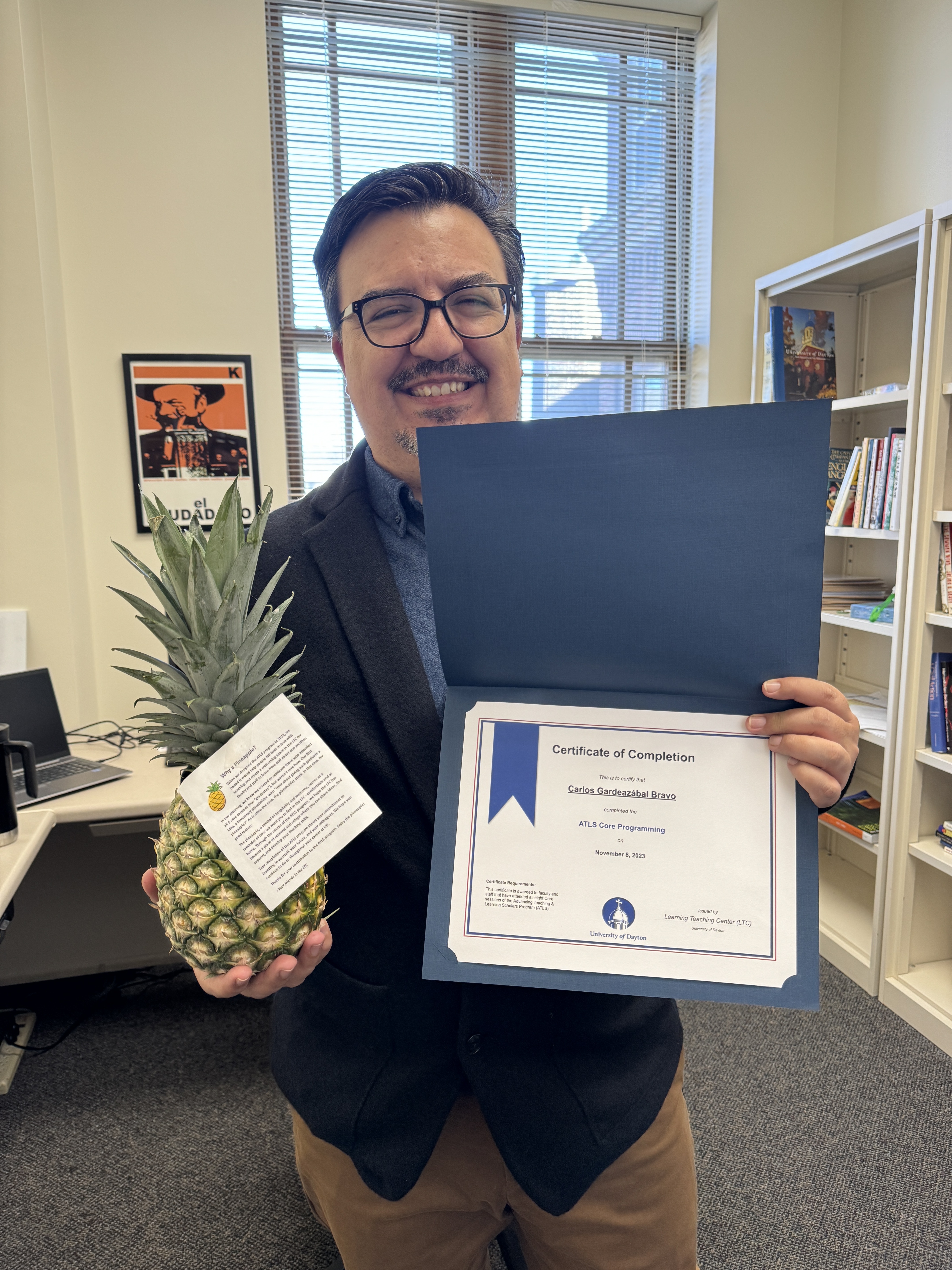 Faculty member Carlos Gardeazábal Bravo poses with a pineapple and diploma to signify graduation from ATLS.