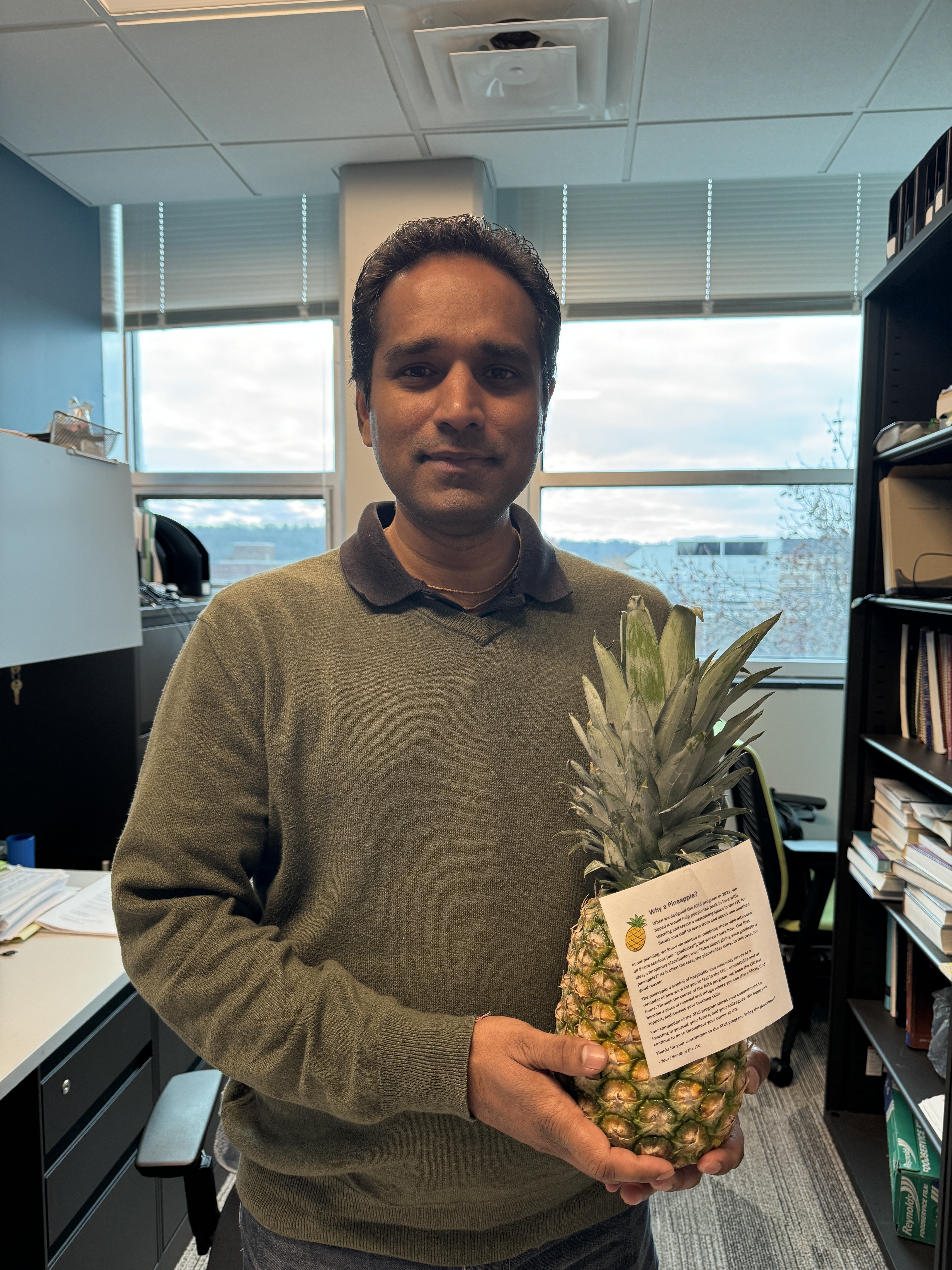 Faculty member Mrigendra Rajput poses with a pineapple and diploma to signify graduation from ATLS.