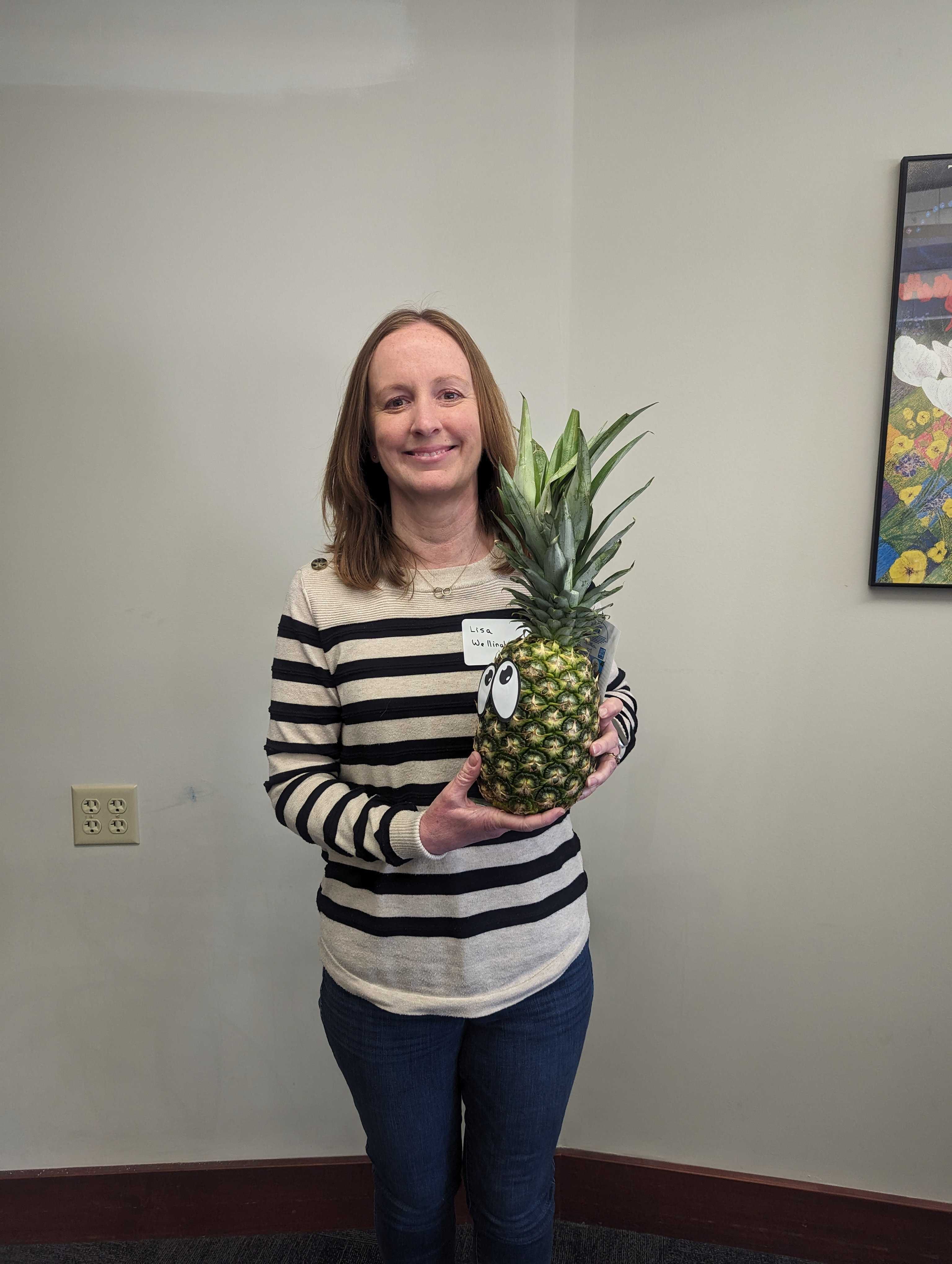 Faculty member Lisa Wellinghoff poses with a pineapple to signify graduation from ATLS.
