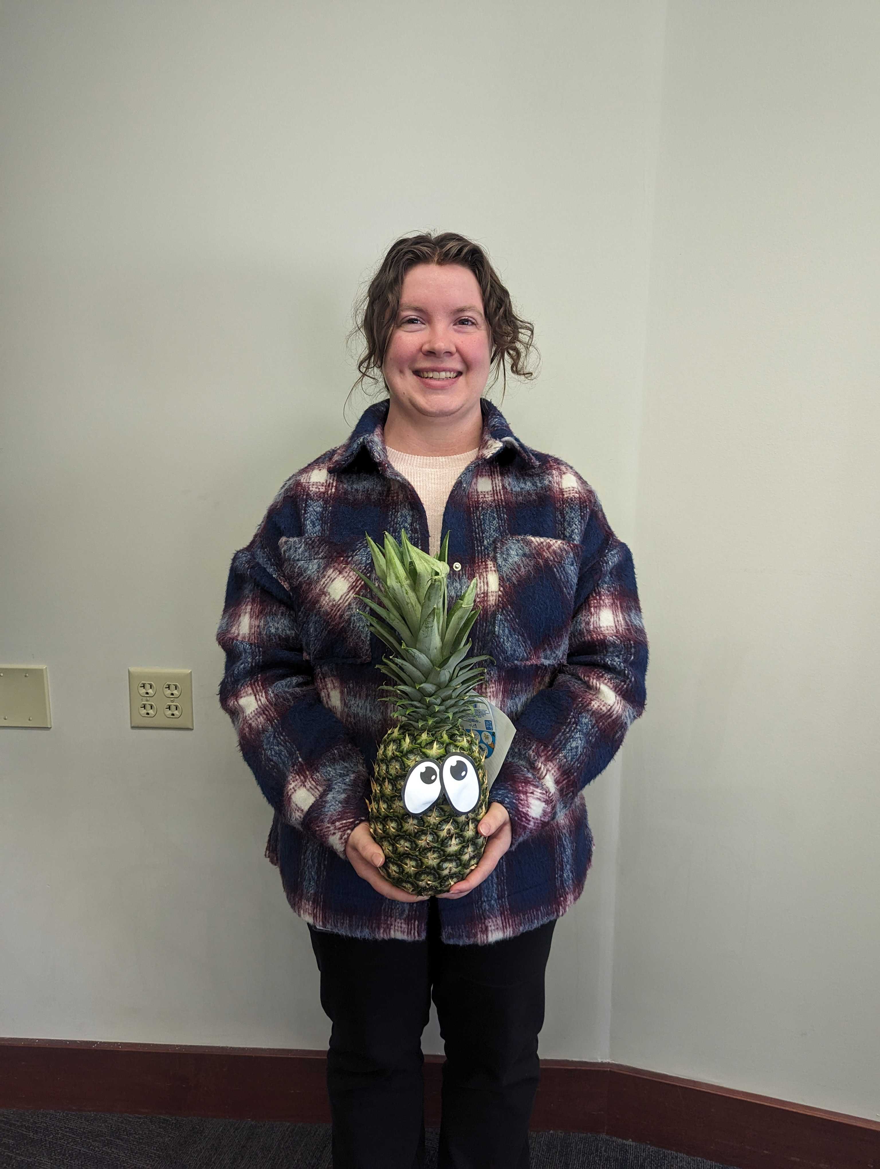 Faculty member Lacie Stiffler poses with a pineapple to signify graduation from ATLS.