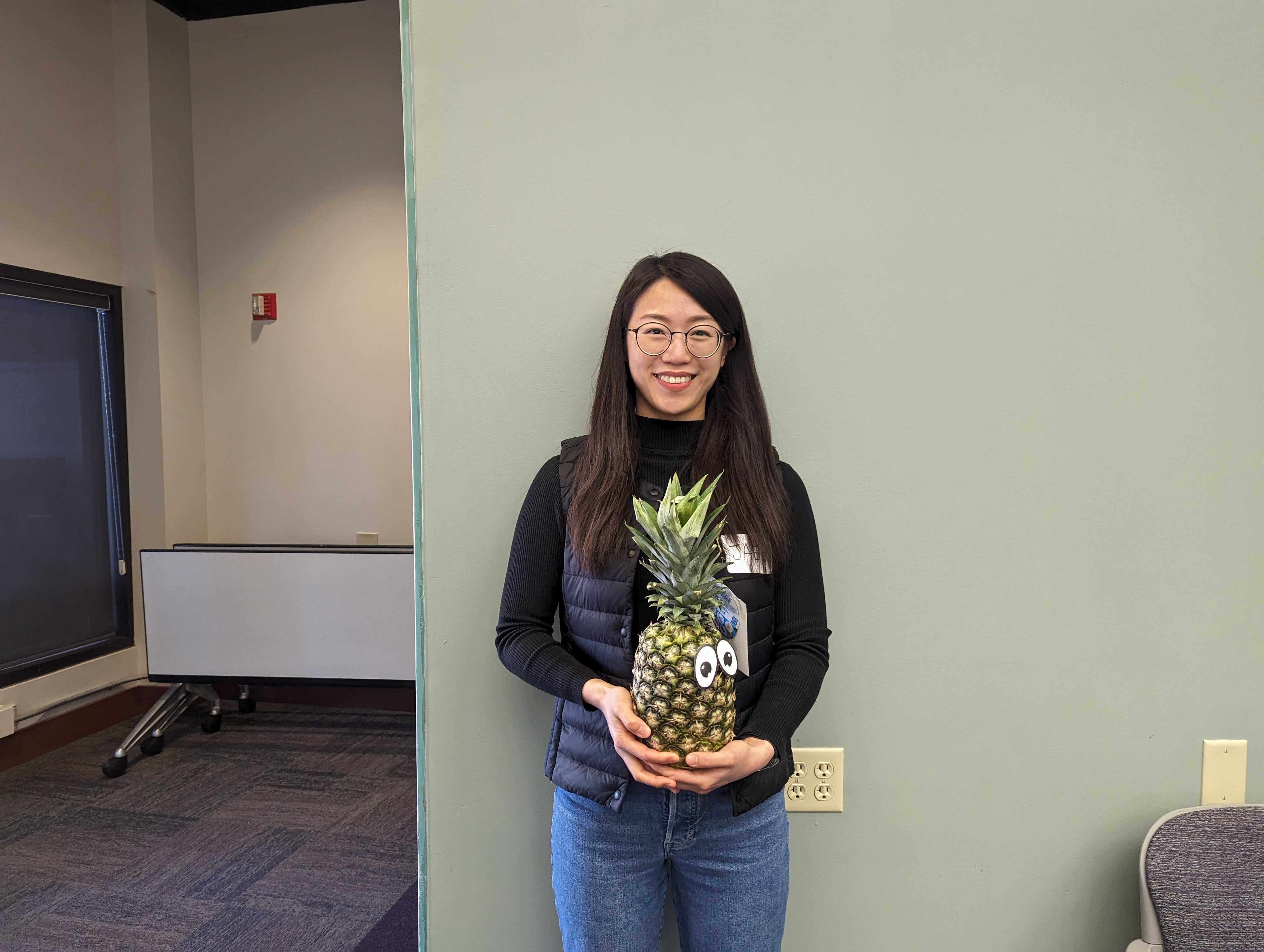Faculty member Jaey Kim poses with a pineapple to signify graduation from ATLS.