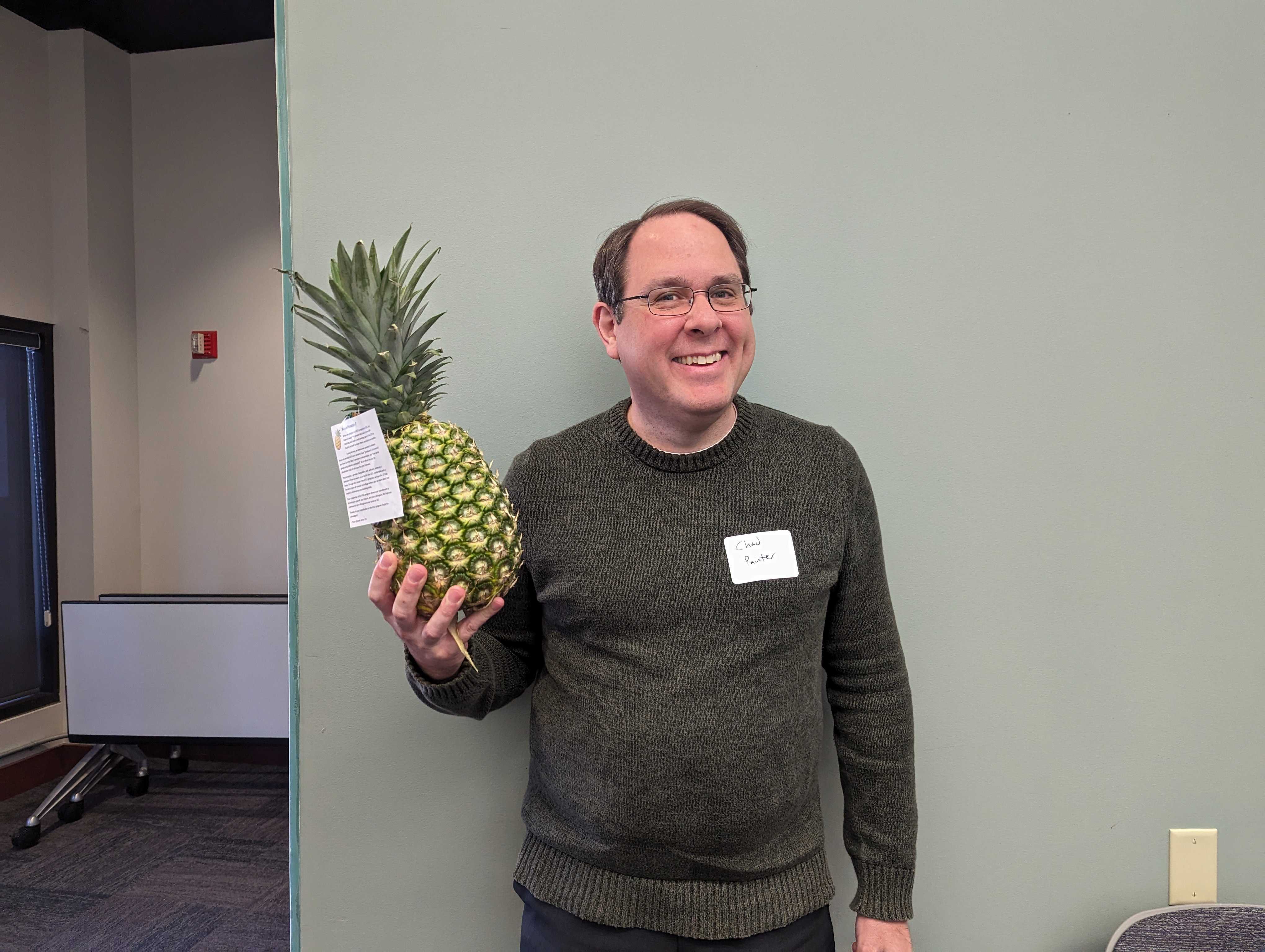 Faculty member Chad Painter poses with a pineapple to signify graduation from ATLS.