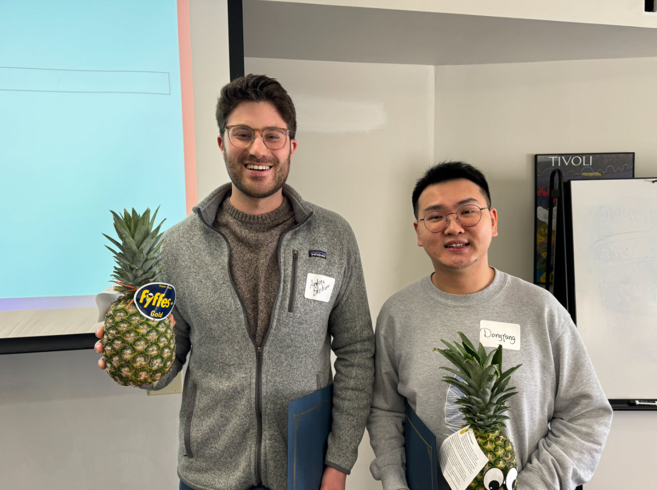 Faculty members Andrew Edelblum and Dongfang Gaozhao with pineapples to signify graduation from ATLS.
