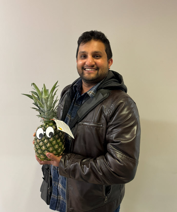 Faculty member Gayan Warahena Liyanage poses with a pineapple to signify graduation from ATLS.