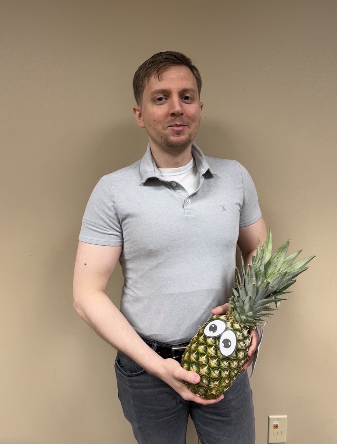 Faculty member Mark Morgan poses with a pineapple to signify graduation from ATLS.
